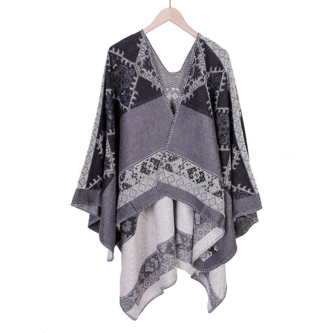 Dam Oversize Ruana poncho tillverkad av jacquard tyg med asymmetrical pointed edge och ornamental border