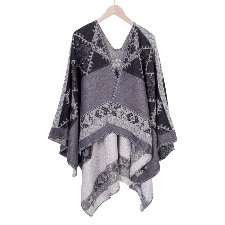 Dam Oversize Ruana poncho tillverkad av jacquard tyg med asymmetrical pointed edge och ornamental border
