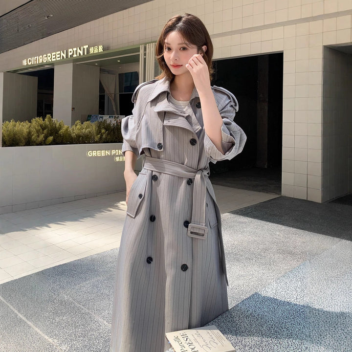Dam lång-skärning pinstripe trenchcoat med voluminous ärmar, shoulder epaulettes, och knytband
