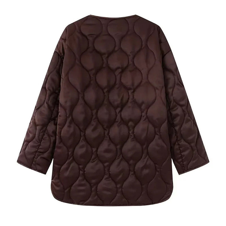 Dam quiltad övergångsjacka i boxy skärning med round neckline, organic wave quiltning, och påsydda fickor