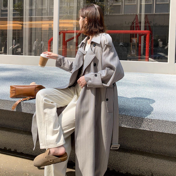 Dam lång-skärning pinstripe trenchcoat med voluminous ärmar, shoulder epaulettes, och knytband