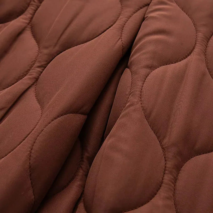 Dam quiltad övergångsjacka med organic wave quiltning, knäppning, och inserted sidofickor