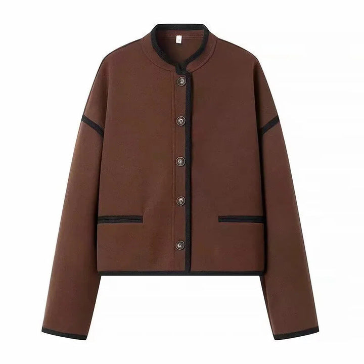 Dam cropped boxy jacka med liten ståkrage, kontrasterande piping, och welt fickor