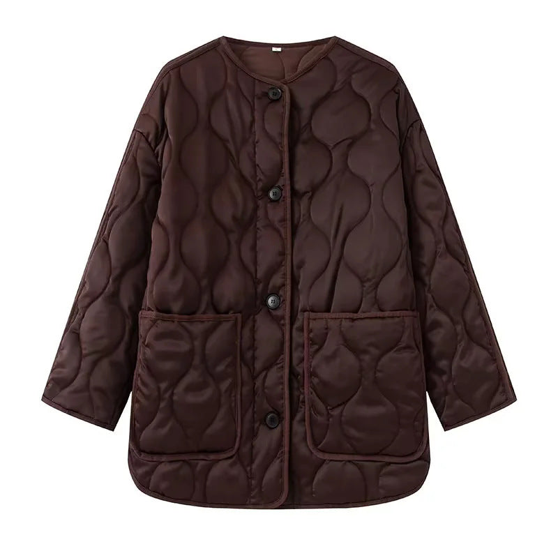 Dam quiltad övergångsjacka i boxy skärning med round neckline, organic wave quiltning, och påsydda fickor