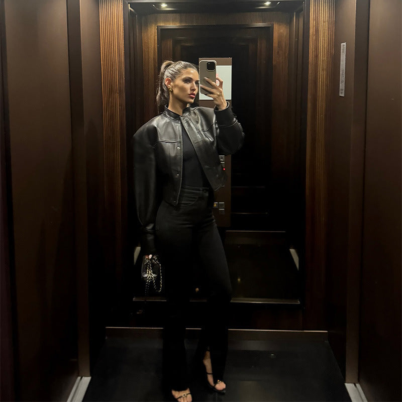 Dam kort jacka gjord vegan smooth läder med prominent shoulder pads och dold snap knappslå