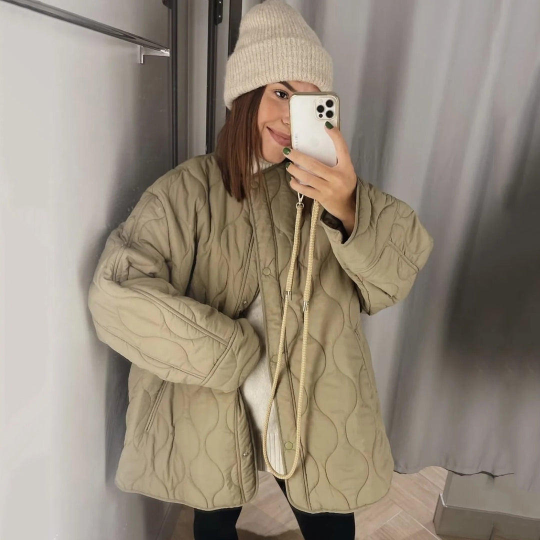 Dam lång modell vadderad jacka med oversize silhuett och stängning med tryckknappar